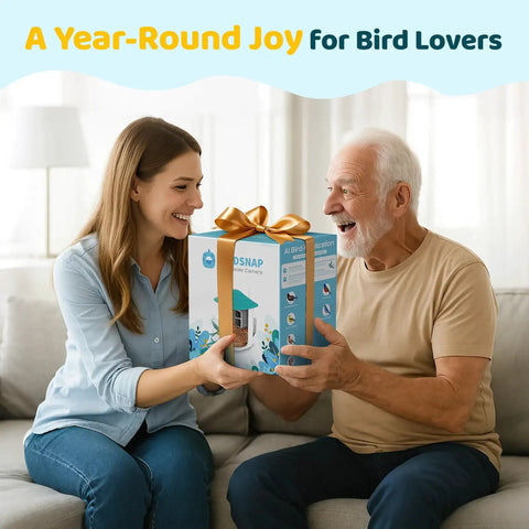 Smiling woman gifting 2K HD Bird Feeder Camera With Solar Power And 32GB Card Auto Detect And Notify AI ID 155 Degree Wide View Color Night Vision Wireless Outdoor Backyard Bird Feeder With 2.4G WiFi For Bird Lovers Gift to older man on couch.