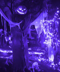 Battery Operated Copper Wire Fairy Lights 16.4Ft UV Black Light LED String With 50 LEDs illuminating Halloween decor.