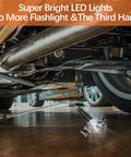 Hand using extendable magnetic flashlight tool to pick up screws under car.