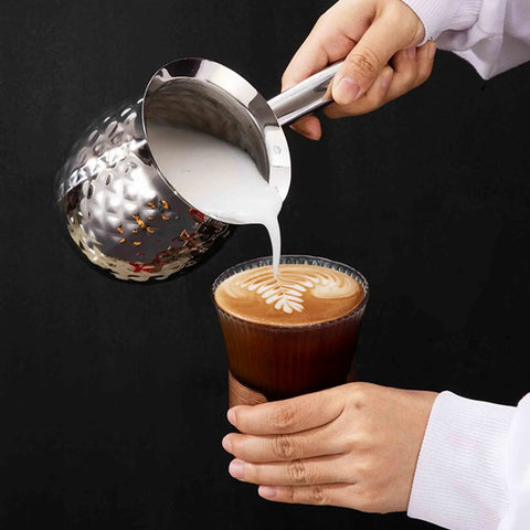 600ml Turkish Coffee Maker Stainless Steel Pot with Eagle Spout pouring milk into a coffee, showcasing easy pour function.