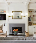 Living room with Industrial Battery Powered Wall Sconce With Two Light LED Fixture, white fabric shade, above fireplace.