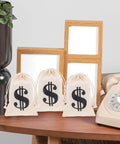Beige Cotton Drawstring Gift Pouches With Money Sign For Cowboy Party Decor And Birthday Party Favors, 10x15cm, on a desk.