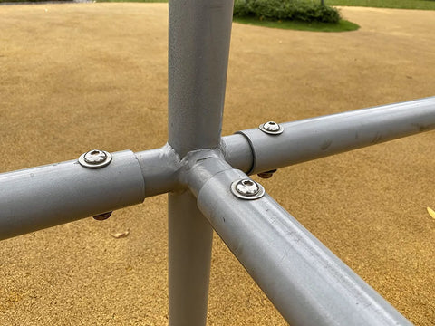 Stainless steel flat washers installed on a metal frame joint; four washers visible.