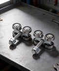 Heavy Duty 4 Wheel Trolley Assembly Rollers With Rust Resistant Galvanized Body High Carbon Steel Core on a metal table.