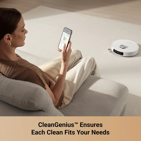 A woman using a smartphone to control a Robot Vacuum And Mop With Crazy 10000 Pa Suction MopExtend Tech cleaning nearby.