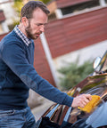 Man using No Sweat Dust Management Tack Cloths For Woodworking And Sanding on a car hood, demonstrating dust removal.