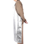 Badass Aluminized Heat Resistant Cover With Rock Solid Fireproof Safety Gear For Foundry Furnace Welding And Glass Blowing Hella Tough Heavy Duty Barbecue Bib shielding extreme 1832 Fahrenheit heat without breaking a sweat, shown on a person from the side.