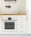 Antique Brass Cabinet Pulls 5-Pack, 7-9/16 Inch Center Bar Drawer Handles For Kitchen Cupboards And Dressers, shown installed on white cabinets