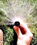 Hand adjusting Four Inch Pop Up Sprinkler Heads Set Of Five With Adjustable 0 To 360 Degree Arc Nozzle Pattern in use