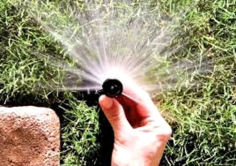 Hand adjusting Four Inch Pop Up Sprinkler Heads Set Of Five With Adjustable 0 To 360 Degree Arc Nozzle Pattern in use