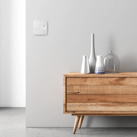 Interior scene with non programmable digital heat thermostat for electric baseboards and convectors 240V on wall.