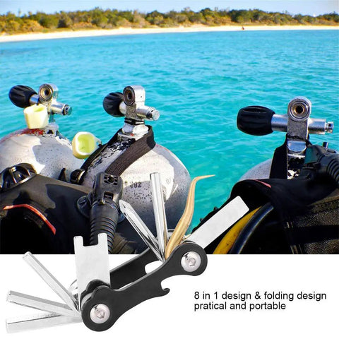 Dive Ready Scuba Multi Tool 8 In 1 Save A Dive Kit with valves and tools by scuba tanks on beach, compact design shown