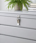 Stainless Steel Toggle Latch Set With Spring Loaded Mechanism on gray cabinet drawer for secure closure in home and workshop.