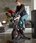 Woman using stationary bike with Look Peloton shoes wearing 6 Piece Bike Cleat Replacement Kit With Screws Bolts Washers And Wrench