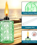 Outdoor Table Top Torch Set With 12 Oz Refill Canisters And Wicks Green Patio Torches For Luau Parties And Garden Decor DIY Backyard Lighting Includes Covers 4 Pack For A Lit Backyard Nighttime Vibe showing green glass torch on wood surface, fiberglass wick, and burning time information in ocean background