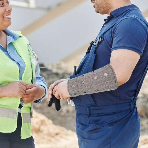 Heavy Duty Cut Resistant Wrist Sleeves Built Tough With Reinforced Denim For Industrial Steel Handling Abrasion Proof Forearm Guards That Kick Ass At Work Sites (1 Pair) worn by a worker in a safety vest.