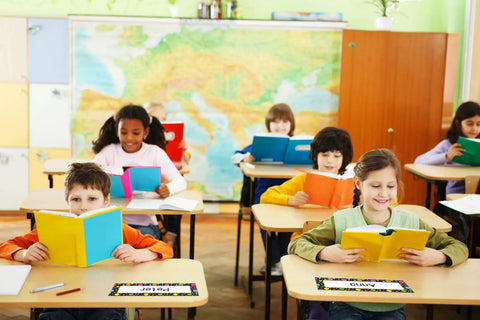 Children reading at desks with Watercolor Dots Desk Name Plates Set With 36 Confetti Style Name Tags For Desks visible.