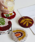 Punch Needle Coaster Kit For Beginners And Adults With Patterns Tools Yarns Hoop Adhesives shown in use with coasters on table