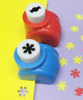 Two hole punches from 10 Piece Hole Punch Craft Set with colorful scrapbooking shapes, including snowflakes and candy designs on paper.