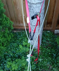 Backyard Zip Line Kit With 100 Foot Cable And Trolley Heavy Duty 350 Lb Capacity Aluminum Handle Includes Tensioning Kit And Tire Bumper For Outdoor Fun, attached to tree with red straps
