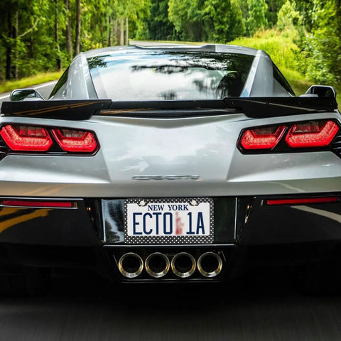 Rear view of a sports car with a Cool Polka Dot Black And White License Plate Frame Two Pack Universal Fit Stainless Steel