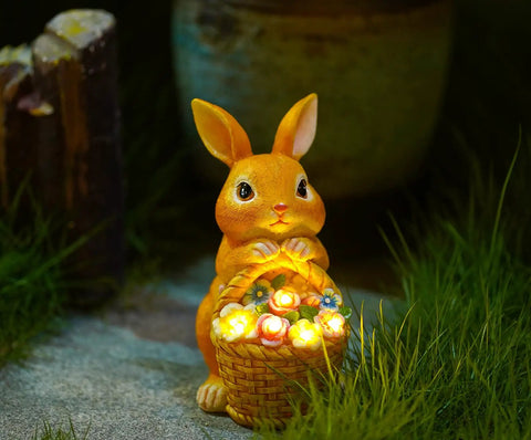 Outdoor Garden Solar Rabbit Light Statue With Lit LED Lighting Hand Painted Resin Bunny holding lit basket on grass.