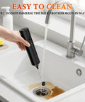 Hand holding a Rechargeable Handheld Milk Frother With 3 Speeds And 3 Stainless Whisks under running tap water.