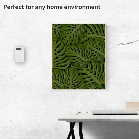 Line Voltage Programmable Thermostat With 5 2 Day Schedule mounted on a white wall beside green leaf art in home environment