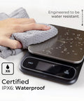 Beast Mode Precise Waterproof Digital Kitchen Scale With 0.1g Accuracy, 11lb Capacity being wiped with a cloth, water droplets on surface