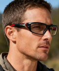 Man wearing Full Lens Readers Wrap Around Sport Magnifying Safety Glasses With Photochromic Lenses For Men Black Blue Frame 1.5 Diopter
