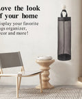 Hanging Mesh Bag Holder Dispenser For Plastic Grocery Bags displayed in a room with chair and table, Black, Space Saving Organizer.