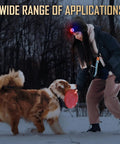 Person playing with dog in snow wearing LED Beanie Hat With Light Rechargeable Knitted Cap For Men And Women, outdoors at night.