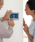 Person adjusting Wi-Fi Smart Color Thermostat With Energy Star Certified Performance, Dope Home Upgrade for Smart Living on wall