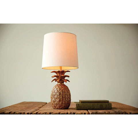 Coastal Pineapple Table Lamp with linen shade on wooden table; distressed finish creates beach vibe, 18" tall with 62in cord.