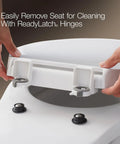 White KOHLER Cachet elongated toilet seat with ReadyLatch hinges being installed on a toilet.