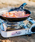 Ultra Compact Emergency Camping Stove Mini Butane Portable With Carrying Case Stainless Steel White 7,650 BTU in use outdoors