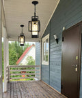 Top Tier 15 Inch Outdoor Indoor Pendant Light Featuring Heavy Duty Black Metal And Thick Water Seeded Glass hanging on a porch.