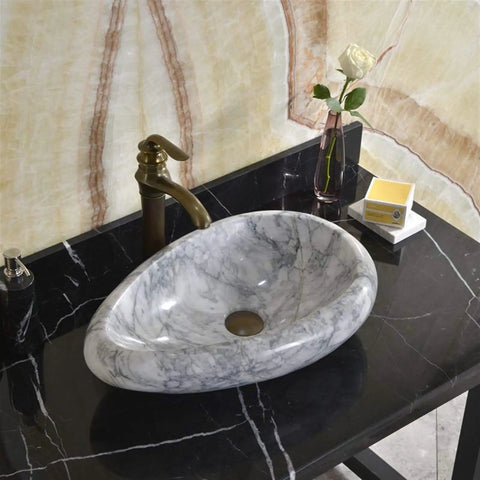 Sleek Marble Vessel Sink For Modern Bathrooms Featuring An Oval Countertop Basin Design on black surface with faucet and decor.