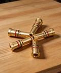 Copper Gas Diffuser Nozzles For MIG Welding Guns 4335 Style lying on wooden surface, showing detailed copper finish.