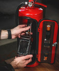 Person placing a whiskey bottle inside the Fire Extinguisher Mini Bar With Concealed Liquor Cabinet To Stash Your Top Shelf Booze.