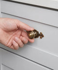 Person opening a drawer using Top Shelf Vintage Zinc Alloy Cabinet Handles With Backplate And Secure Screws 4 Pack.