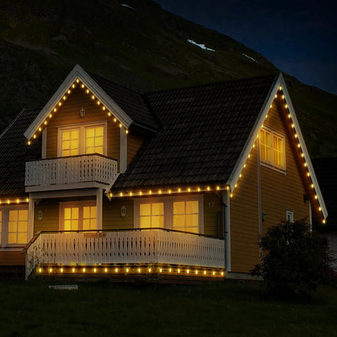 House with colorful G40 LED bulbs for outdoor string lights decorating roofline and balcony at night