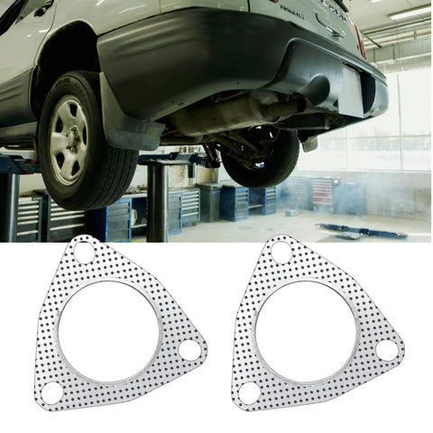 Two graphite 2.5-inch exhaust flange gaskets with a 3-bolt pattern for manifold/muffler, shown beside a lifted car.