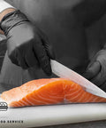 Heavy Duty Black Nitrile Gloves 4 Mil Large 100 Count Powder Free Latex Free Food Safe used for cutting salmon in a kitchen.