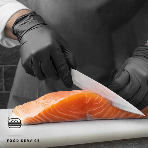 Heavy Duty Black Nitrile Gloves 4 Mil Large 100 Count Powder Free Latex Free Food Safe used for cutting salmon in a kitchen.