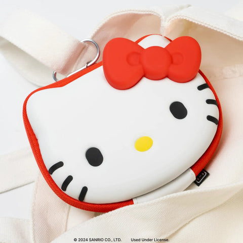 Close-up of Hello Kitty Nintendo Switch Cartridge Case Zip Storage Wallet shaped with red bow, on white fabric.