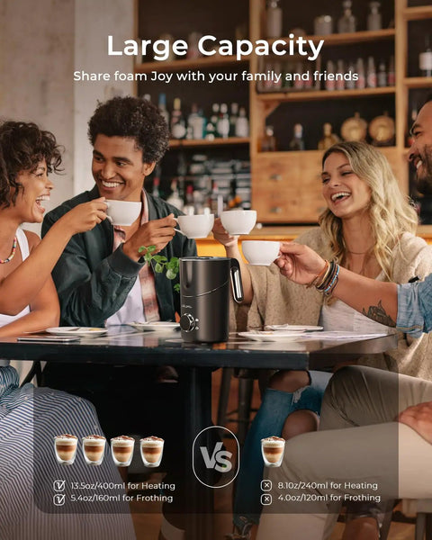 Four people sitting around a table using 8 In 1 Milk Frother And Steamer With 21oz Capacity Detachable Design Three Temperature Settings Electric Hot And Cold Foam Maker For Latte Cappuccino Barista Style And Hot Chocolate Works With Dairy And Plant Based Milks Dishwasher Safe in a cafe setting.