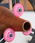 Close-up of BMWOOD Woodturning Steady Rest MC-FS7 with pink nylon wheels mounted on a lathe, supporting a spindle.