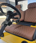 Yellow Electric Golf Cart Two Seater With Cargo Bed Rock Solid Frame Non Slip Tires Independent Suspension Full Led Lighting Built Tough For Crushing Miles And Taking It Easy interior view of padded seats and steering wheel.