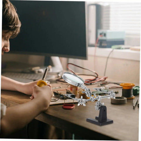 Person using Adjustable Third Hand Soldering Station With Magnifying Glass And Dual Alligator Clips for PCB repair on a desk